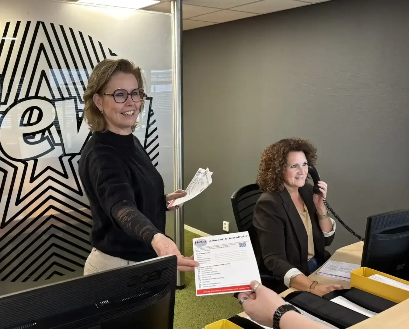 Vrouwelijke management assistent ontvangt document in kantooromgeving.