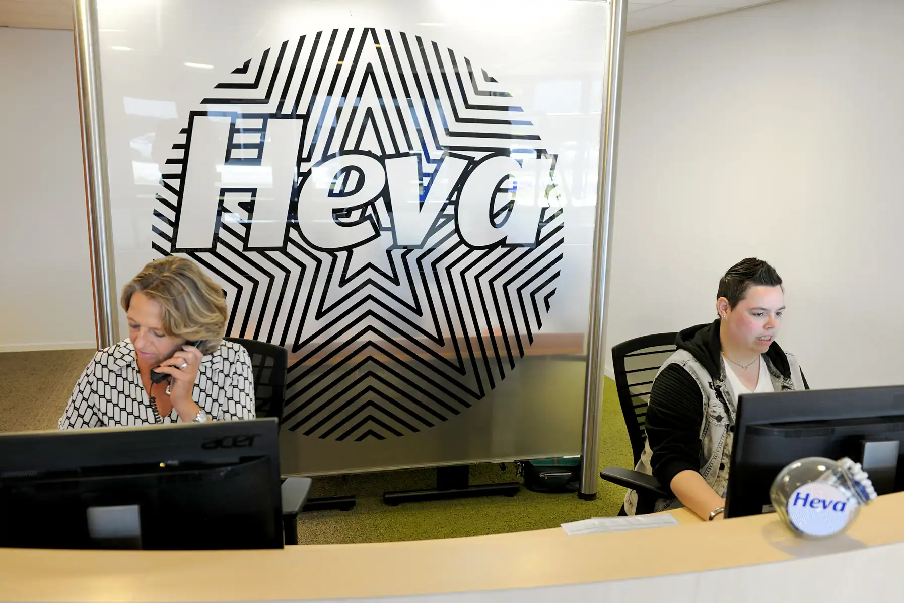 Klantgerichte medewerkers bij Heva werken aan computers in kantooromgeving.