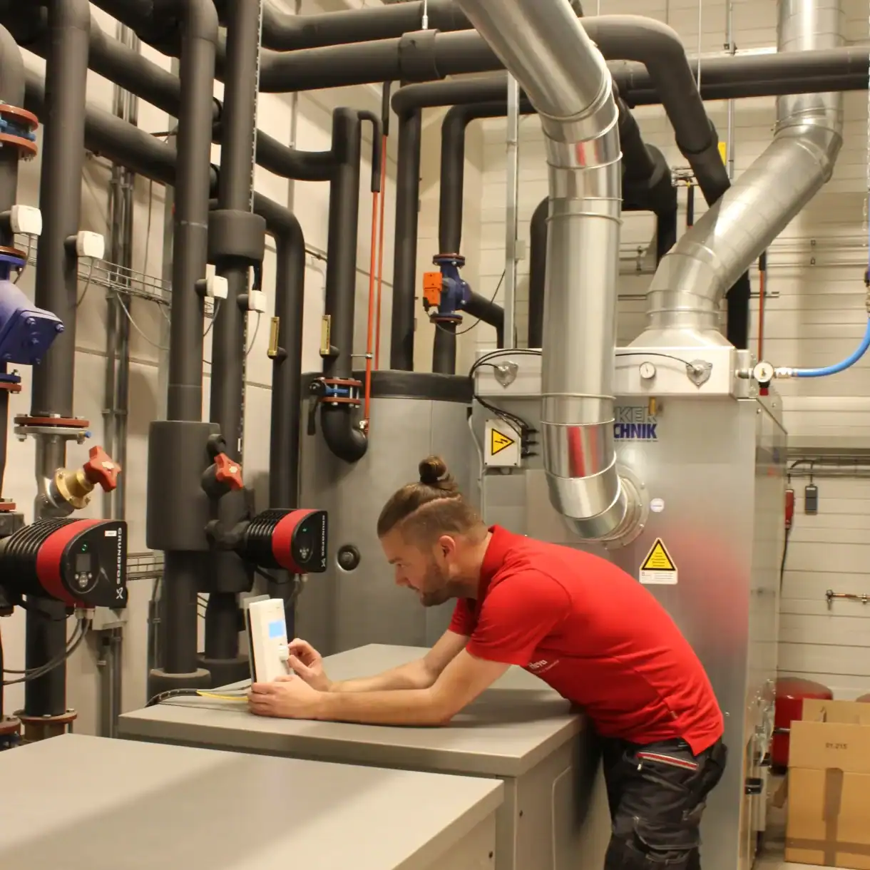 Elektricien controleert apparatuur in technische ruimte bij Heva.